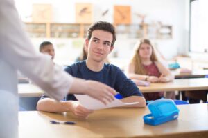 Student getting results of essay checked with an AI text detector in the classroom