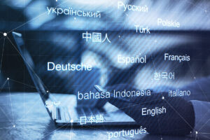 Cross language concept - an open laptop with a person on their phone, and different languages overlayed across the screen